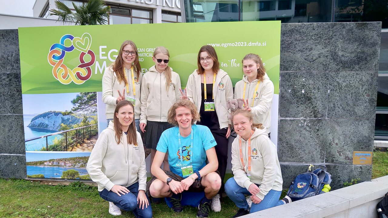 Eesti esindus 12. Euroopa tüdrukute matemaatikaolümpiaadil. Tagumises reas vasakult õpilased: Meriliis Täht, Agnes Tennisberg, Kirke Kisand, Liisa Pata. Esireas vasakult: Sandra Schumann (võistkonna juhendaja), Jakob Schrader (võistkonna giid), Birgit Veldi (võistkonna juhendaja).
