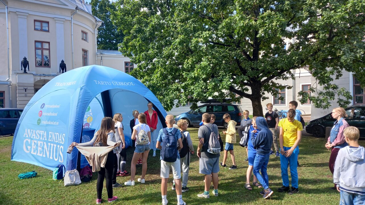 Tartu Ülikooli teaduskooli telk ja lapsed selle ees.