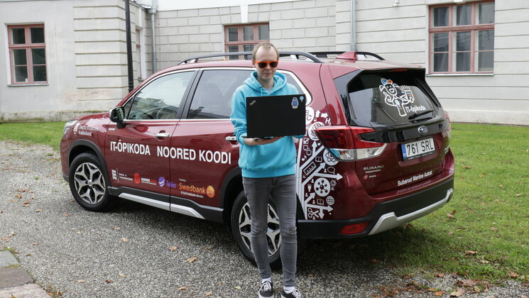 Teaduskooli töötaja IT-õpikodade auto ees.