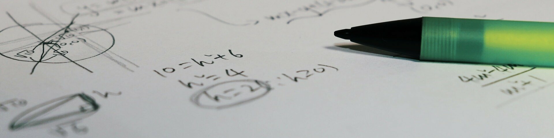 Valgel paberil on matemaatilised sümbolid ja heleroheline pastapliiats.