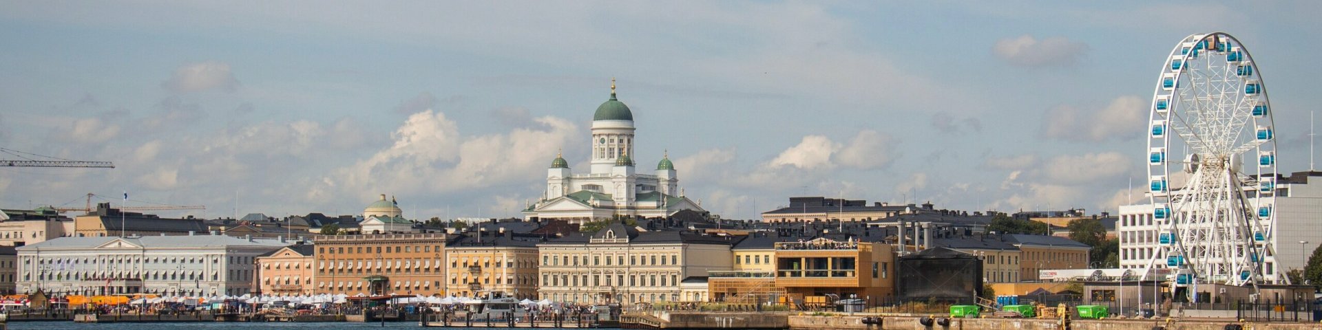 Helsingi linnavaade pastelsetes värvides hoonete ja vaaterattaga.